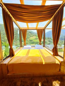 a bed in a room with a large window at Glass House Merisi 2 in Merisi