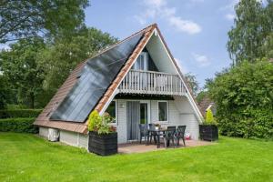 a tiny house with a thatched roof at Vijverzicht de Goudkarper 154 in Gramsbergen