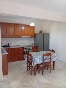 a kitchen with a table and chairs and a refrigerator at Villa Lagosta in Város