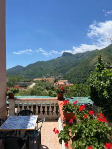 a table and chairs on a balcony with mountains at Antica Casa Cavaliere in Tramonti