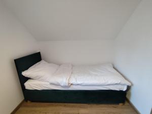 a unmade bed with white sheets in a room at Osada ŁYSKA in Żywiec