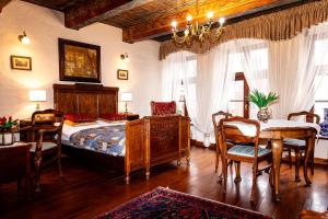 a bedroom with a bed and a table and chairs at Apartamenty Molus na Rynku Staromiejskim in Toruń