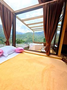 a bedroom with a bed in front of a large window at Glass House Merisi 2 in Merisi