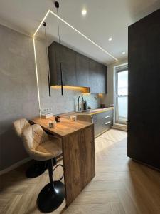 a kitchen with a wooden table and a chair at Mabelle Gold Stay in Baia Mare