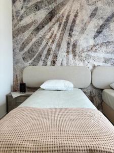 a bed in a room with a wall mural at MariZot Apartment in Alexandroupoli