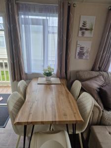 a table and chairs in a living room with a couch at Riley's Caravan sand le mere tunstall view in Tunstall