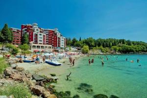 a beach with a bunch of people in the water at Apartament BEACH VIBES Nessebar in Nesebar