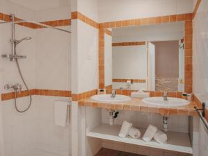 a bathroom with two sinks and a shower at Hotel de la Plage in Le Lavandou