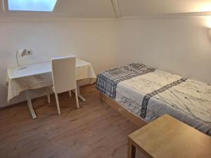 a room with a bed and a desk and a table at Ferienwohnung Rieder in Wörgl +3 photos