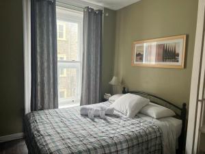 a bed in a bedroom with a window and a blanket at Auberge St-Louis in Quebec City