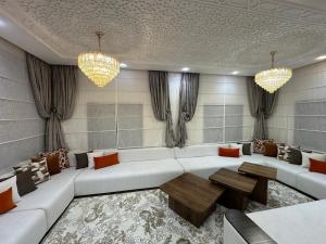 a living room with a white couch and a table at Villa ghmate in El Kriet