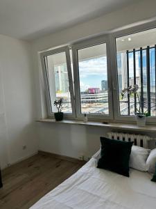 a bedroom with a bed and windows with a view at Metro Central 3 Rooms Apartment in Warsaw
