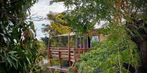 a tree house with a deck with an umbrella at Calme et Nature in Saint-Leu