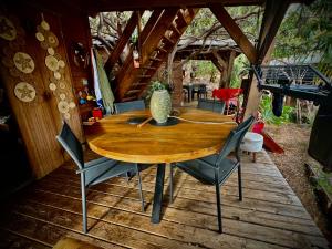 a wooden table and chairs on a wooden deck at Calme et Nature in Saint-Leu
