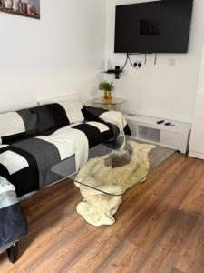 a living room with a couch and a glass table at Stylish and Modern Space in Shenley Brook End