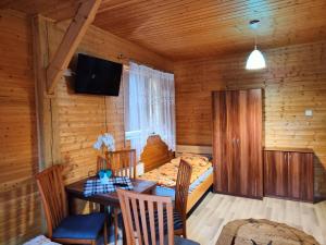 a room with a table and a bed and a bedroom at Dom Rybaka Bobolin in Bobolin