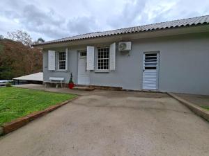 a white house with a driveway in front of it at Casa Finger próx do Centro e do Núcleo de Casas Enxaimel ambiente familiar in Ivoti