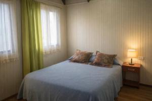 a bedroom with a bed with two pillows on it at Refugio Pradera del Sur in Llanquihue