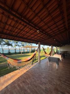 a patio with a hammock and a table and chairs at Suítes icarai vila in Caucaia