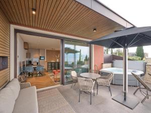 a patio with a table and chairs and an umbrella at Luxury Apartments La Baia - Penthouse in Torri del Benaco