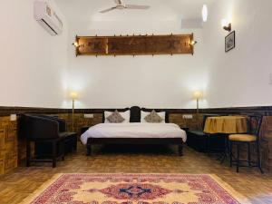 a bedroom with a bed and a table and chairs at Haveli Expedition & Resort in Ghānerao