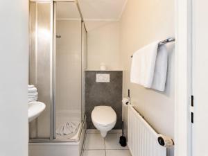 a small bathroom with a toilet and a shower at Dana Living Apartment Bremen HBF - Zentrum, Altstadt, Messe, ÖVB Arena, Business Apartment mit Self Check-in in Bremen +38 photos