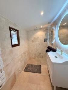 a bathroom with a sink and a mirror at Villa Romance Intime Prestige -Jacuzzi Privatif, , Table a massage , Fauteuil tantra, Balançoire romantique in Vienne +19 photos