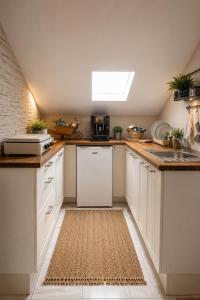 a kitchen with white cabinets and a white refrigerator at Appartamentino Mansardato in Pedara