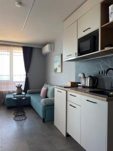 a kitchen and living room with a blue couch at Апартаменти Генезис Ахтопол in Ahtopol +13 photos
