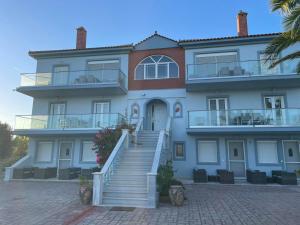 a large white building with stairs in front of it at Villa Lagosta in Város