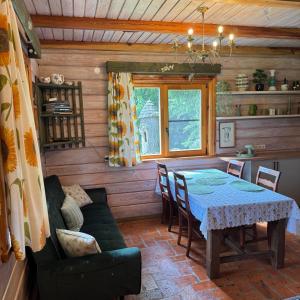 a dining room with a table and a couch at Namelis Bitidė, sodyba Latkrantė, Druskininkai in Latežeris