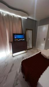 a bedroom with a tv and a bed and a mirror at Flat no Centro da Cidade in Parauapebas