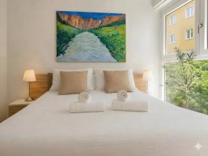 a bedroom with a white bed with a large window at Emerald Apartment City Center in Lugano