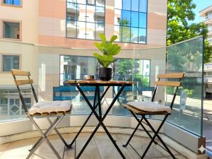 a table with two chairs and a plant on a balcony at Emerald Apartment City Center in Lugano