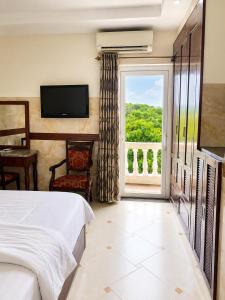 a bedroom with a bed and a large window at Hotel HOÀNG THANH THỦY BÀ RỊA - VŨNG TÀU in Ho Coc +25 photos