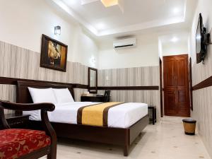 a hotel room with a bed and a chair at Hotel HOÀNG THANH THỦY BÀ RỊA - VŨNG TÀU in Ho Coc