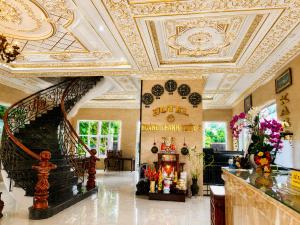 a lobby with a staircase and a gold ceiling at Hotel HOÀNG THANH THỦY BÀ RỊA - VŨNG TÀU in Ho Coc