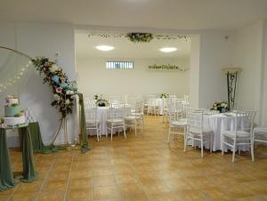 a room with white tables and chairs and flowers at Al Boschetto in Melizzano