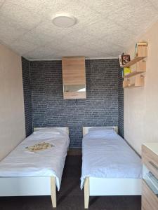 two beds in a room with a brick wall at Ribnica in Ribnica