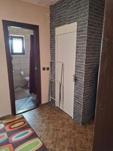 a bathroom with a brick wall and a door at Ribnica in Ribnica +17 photos