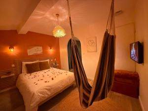 a bedroom with a hammock hanging from the ceiling at Villa Romance Intime Prestige -Jacuzzi Privatif, , Table a massage , Fauteuil tantra, Balançoire romantique in Vienne