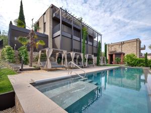 a swimming pool with chairs next to a building at Luxury Apartments La Baia - Penthouse in Torri del Benaco