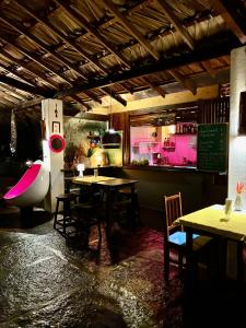 a dining room with tables and chairs and pink lighting at Casa Acquamarina in Atins