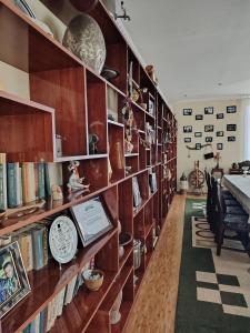 a library with wooden shelves filled with books at Family Guest House SadNur in Bukhara