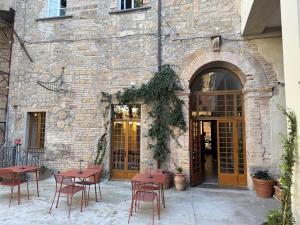 a patio with tables and chairs in front of a building at Hotel Posta - palazzo Guidoni in Orvieto