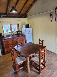 a kitchen with a wooden table and chairs and a refrigerator at Alma de Algarrobo in San Javier +24 photos