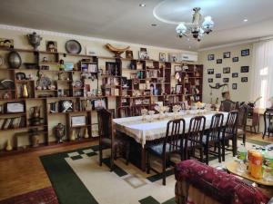 a dining room with a table and a lot of shelves at Family Guest House SadNur in Bukhara