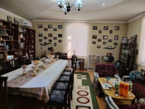 a dining room with a long table with glasses on it at Family Guest House SadNur in Bukhara