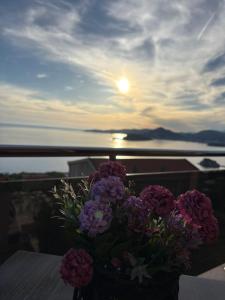 a vase of flowers sitting on a table with the sunset at Sunset Residence Blizikuce in Budva