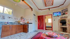 a kitchen with a red door and a fireplace at Adrar N Darn Guesthouse in Taroudant